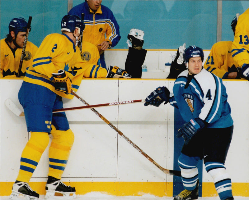 Judge Kerry Hilton Fraser jumps on the rink to take shelter during the ice hockey match Sweden - Finland during the Winter Olympics in Nagano 1998 - Vintage Photograph