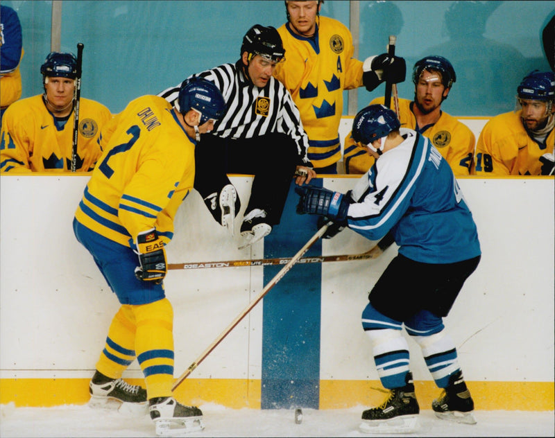 Judge Kerry Hilton Fraser jumps on the rink to take shelter during the ice hockey match Sweden - Finland during the Winter Olympics in Nagano 1998 - Vintage Photograph