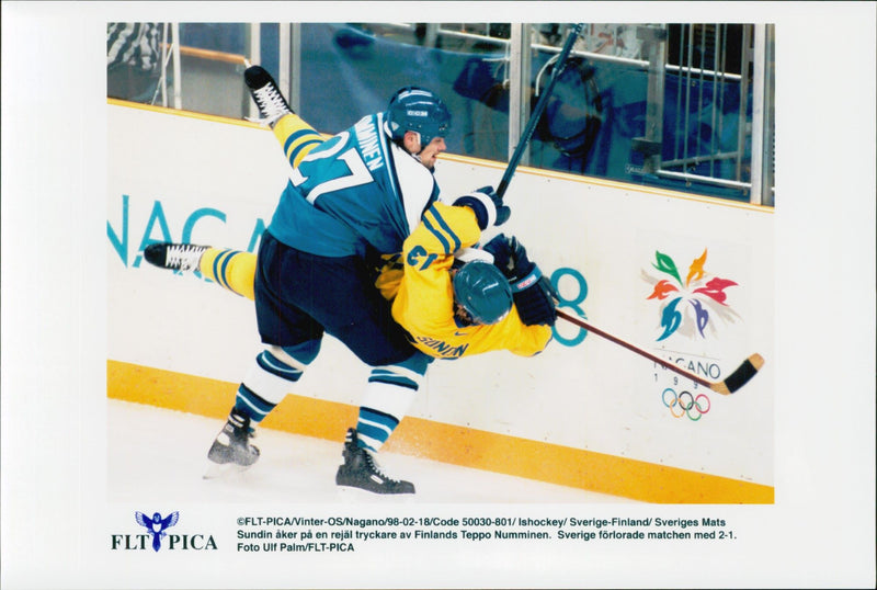 Mats Sundin goes on a massive printer of Teppo Nummin during the ice hockey match Sweden - Finland during the Winter Olympics in Nagano 1998 - Vintage Photograph