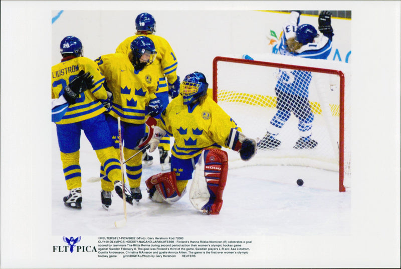 Finlands Hanna-Riikka Nieminen hejar över lagkamraten Tiia-Riitta Reima mål under ishockeykampen Sverige - Finland under vinter-OS i Nagano 1998 - Vintage Photograph