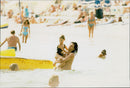 Singer Michael Hutchence is bathing together with daughter Tiger Lily. - Vintage Photograph
