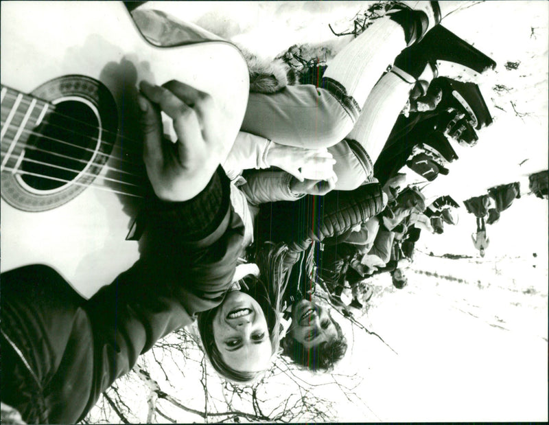Pedestrians take a break in the ski slope with some guitar music - Vintage Photograph