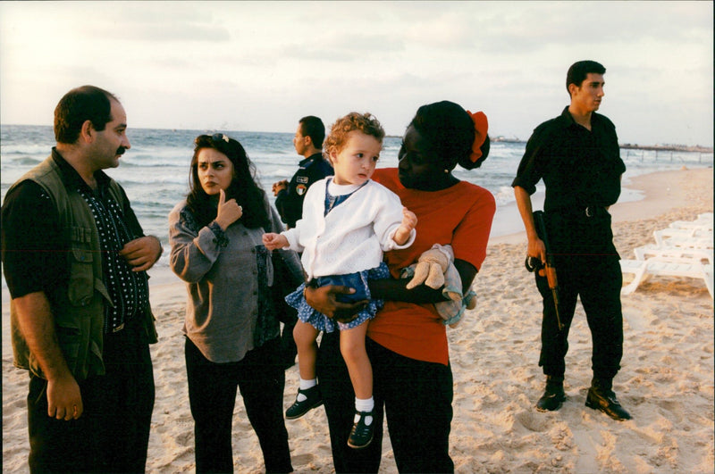Suha and Yassir Arafat's daughter Zahwa on the shore of Gaza under constant guard of bodyguards - Vintage Photograph