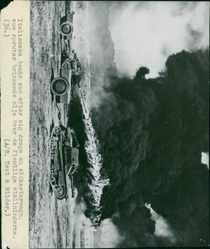 Italian tanks that, afterwards, draw a fire truck that sparks burning oil over the hostile settlers - Vintage Photograph