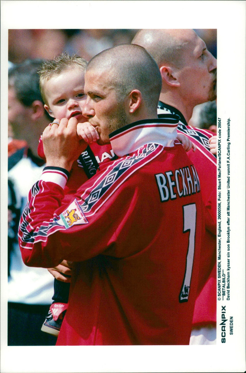 David Beckham kisses his son Brooklyn after Manchester United has won F.A. Carling Premiership - Vintage Photograph